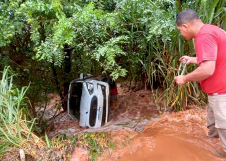 Enxurrada leva carro com motorista para dentro de córrego em Vicentina