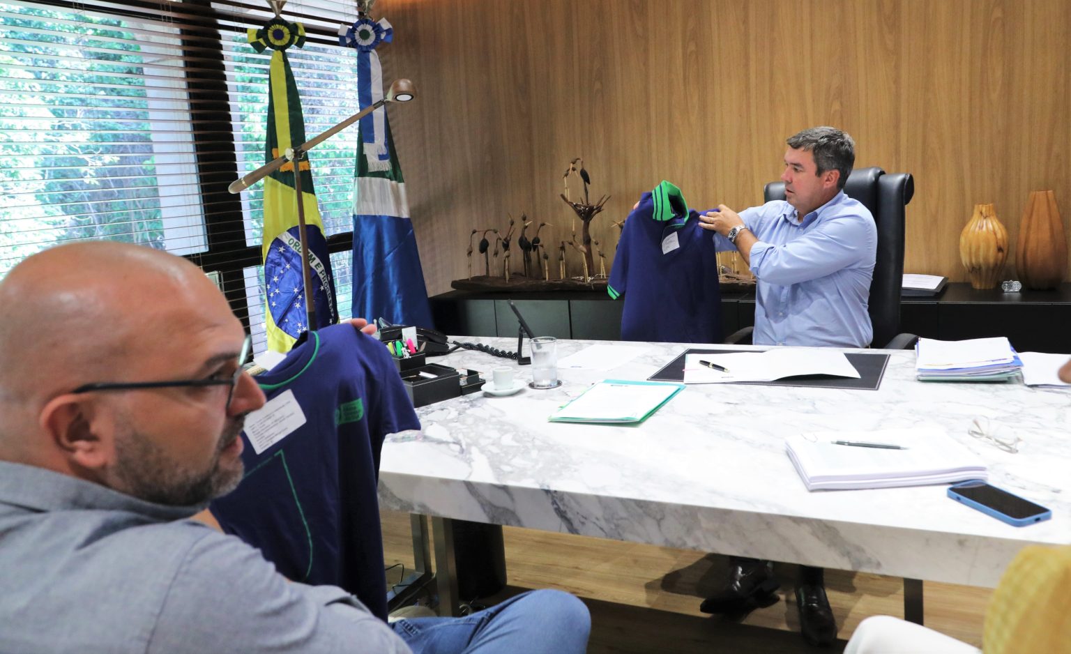 Camiseta polo (nas mãos do governador) será dos administrativos; modelo dos alunos está com o secretário Hélio Daher -Foto: Saul Schramm